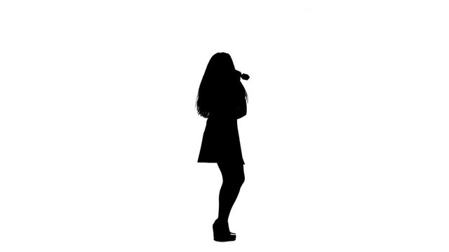 Singer in the dress sings the songs into the microphone. White background. Silhouette. Side view. Slow motion