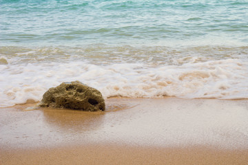 Beach of Bali / Stone is covered by white foam of wave 