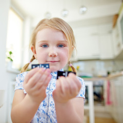 Kind h&auml;lt zwei Dominosteine in den H&auml;nden