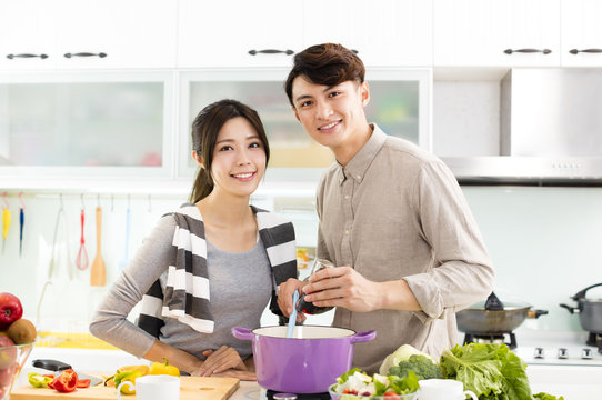 young asian couple cooking in kitchen