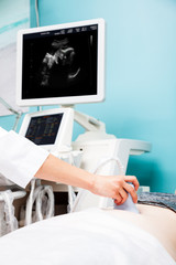 Doctor performing obstetric ultrasonography on a pregnant woman