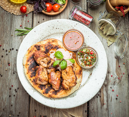 two pieces of of grilled pork with herbs on a paper