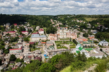 Fototapeta na wymiar Top aerial city landscape close up view. Kremenets, Ukraine. Old buildings with peeling paint. Beautiful churches Baroque style and green park