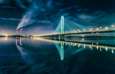 The South bridge at night, Kiev, Ukraine. Bridge at sunset across the Dnieper River. Kiev bridge against the backdrop of a beautiful sunset in Kiev. Bridge in evening sunshine.