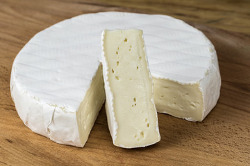 Fototapeta na wymiar Camembert cheese brie.Triangle cut-out placed vertically.