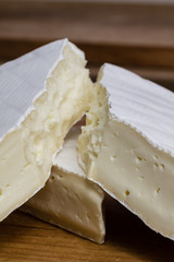 Close up of Camembert cheese. Brie with coarse edge broken into pieces cremy and delicious.