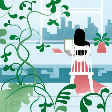 Woman working on laptop computer by window, skyscrapers in background