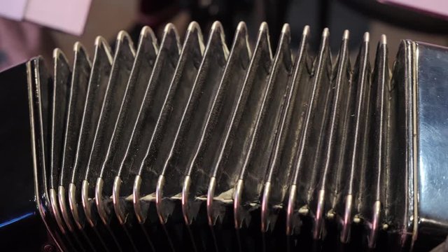 Playing on a big accordion. Playing the harmonica close-up. Old musical instrument Russian bayan - button accordion close-up