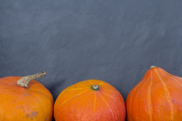 three pumpkins on black background