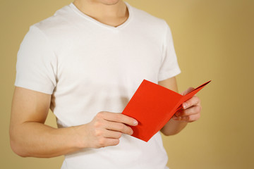 Man reading blank red flyer brochure. Read detailed booklet. Leaflet presentation. Pamphlet hold...