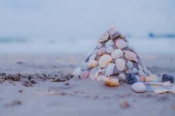 Sand castle on sandy beach with shells wall decorated, added color filter