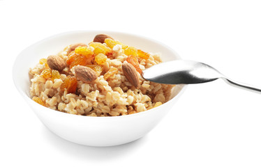 Tasty oatmeal with raisins and almond in bowl on white background