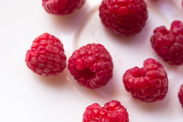 raspberries on a white saucer close up