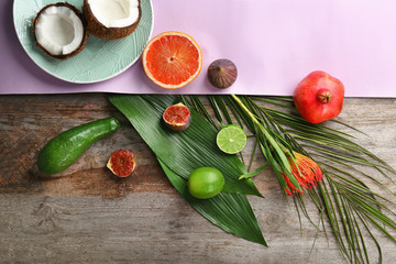 Composition with tropical leaves and exotic fruits on table