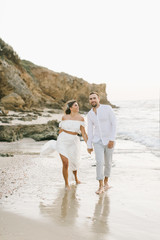 A loving couple is walking on the beach