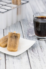 Fresh made Cola Popsicles on wooden background