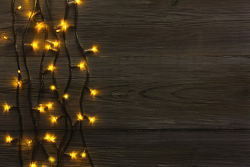 Christmas lights border on grey wooden background