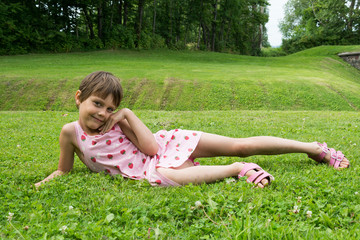 Naklejka na ściany i meble a girl in nature poses on the grass