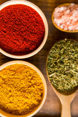 Various colorful herbs and spices on wooden table