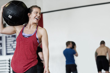 Woman Carrying Medicine Ball On Shoulder