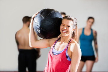 Smiling Female Trainer Carrying Medicine Ball