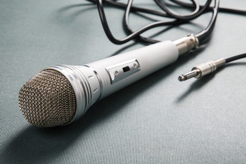 Microphone silver with a wire on a ridge background