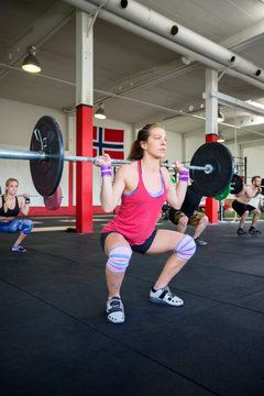 Female Lifting Heavy Barbell In Gym