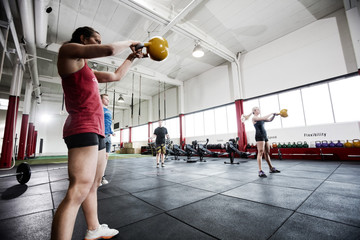 Obraz na płótnie Canvas Women And Men Exercising In Gymnasium