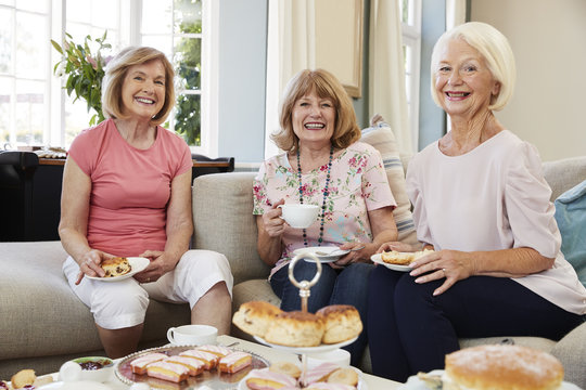 Portrait Of Senior Female Friends Enjoying Afternoon Tea At Home - Powered by Adobe