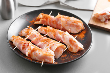 Plate with bacon wrapped chicken nuggets on table