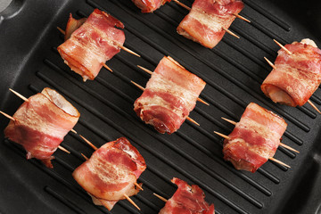 Bacon wrapped chicken nuggets on grill pan, closeup
