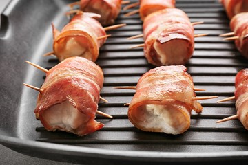 Bacon wrapped chicken nuggets on grill pan, closeup
