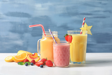 Glassware with different milkshakes on table