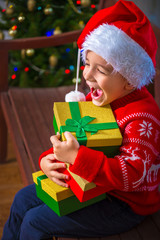 Portrait of a happy child with a gift on the background of a Christmas tree