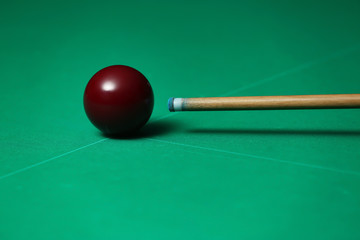 Billiard ball and cue on table