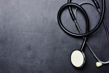 Medical background with stethoscope on blackboard 