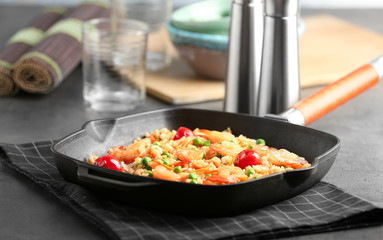 Frying pan with delicious shrimp fried rice on table