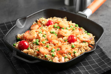 Frying pan with delicious shrimp fried rice on table