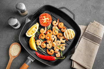 Frying pan with delicious grilled shrimps on table
