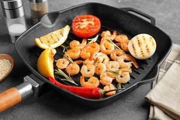 Frying pan with delicious grilled shrimps on table