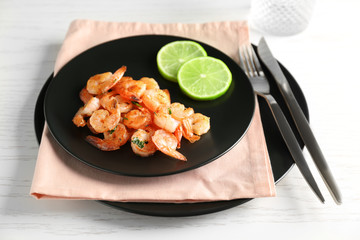 Plate with delicious grilled shrimps on table