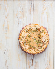 Autumn background with pumpkin pie, hot tea, yellowed leaves, book and rug. Perfect sunny autumn. A wooden light white autumn background for you. Copy Space. Place for text. Flat lay, top view