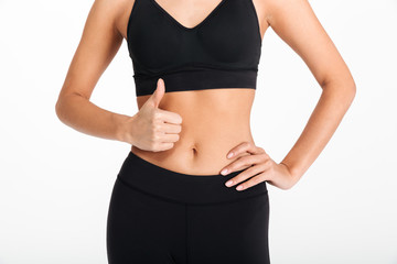 Cropped picture of young sports woman showing thumbs up.