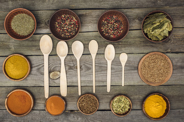 wooden spoons among bowls with spices