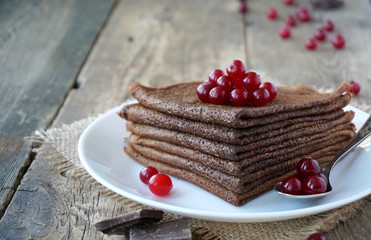 Chocolate pancakes decorated with cranberry