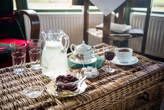 Table with Strong Turkish style coffee in a cup on a table with sugar pot, turkish delight, jar of lemonade and cranberries snaps and cranberries in the jar