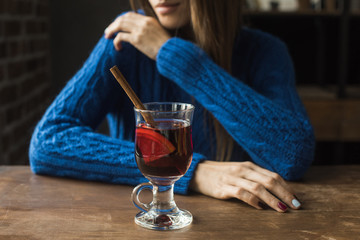 woman sitting with glass of mulled wine