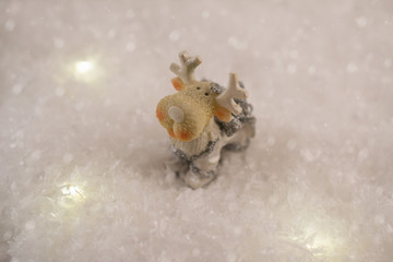New Year card with toy deer in a fairy forest  on winter background with snow and lights. Template, greeting card