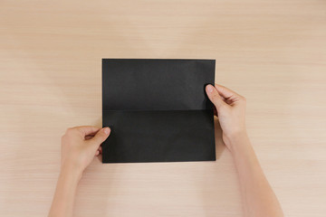 Hands holding blank black brochure booklet in the hand. Leaflet presentation. Pamphlet hand man....