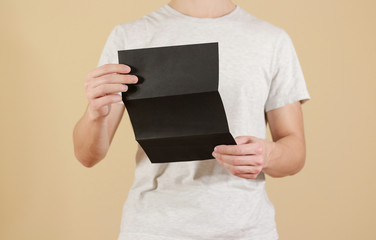 Man showing blank black flyer brochure. Read detailed booklet. Leaflet presentation. Pamphlet hold...